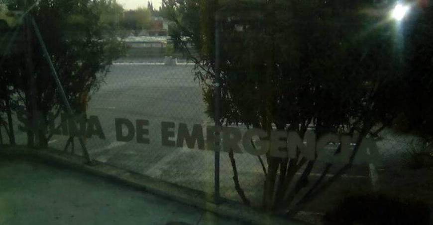 Una ventana en donde se lee "salida de emergencia" se ven árboles