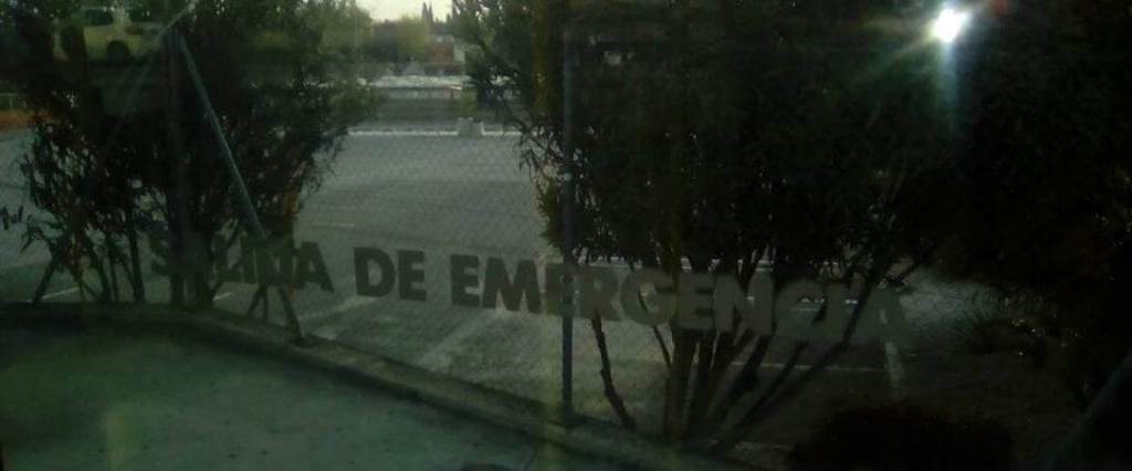Una ventana en donde se lee "salida de emergencia" se ven árboles